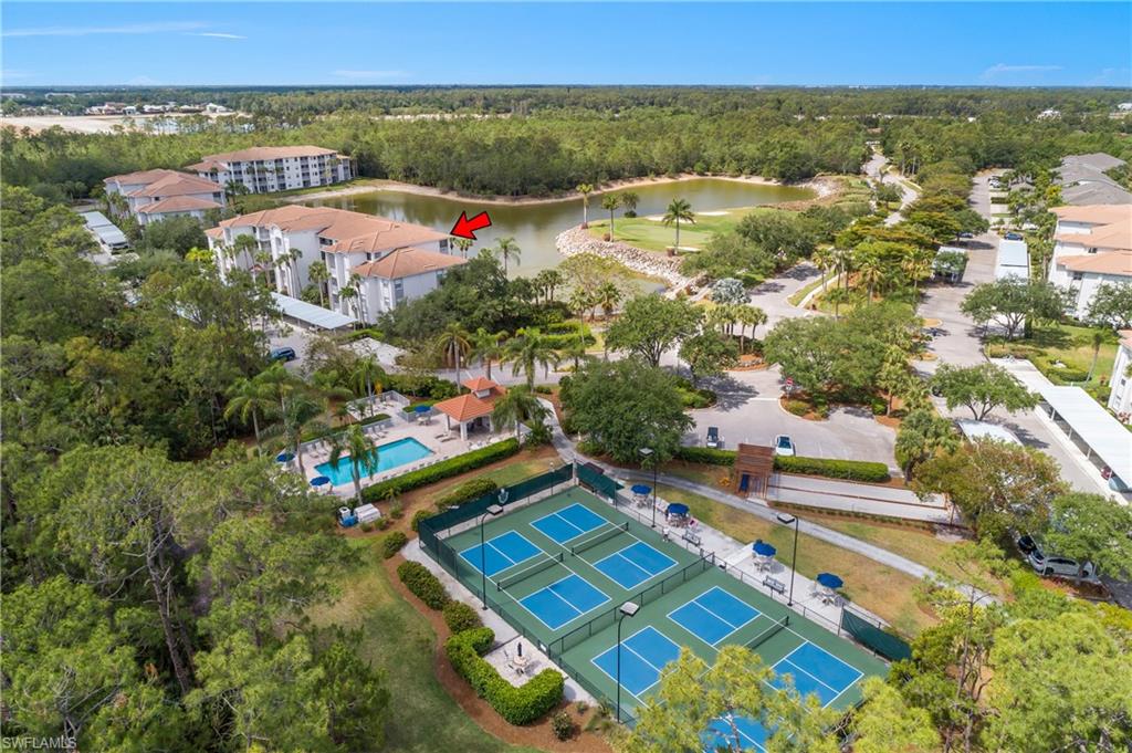 Drone / aerial view with a view of trees, a water view, and golf course view