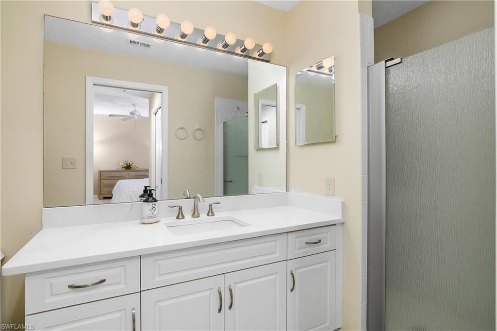 Primary Ensuite bathroom featuring ceiling fan, visible vents, a stall shower, vanity, and ensuite bathroom