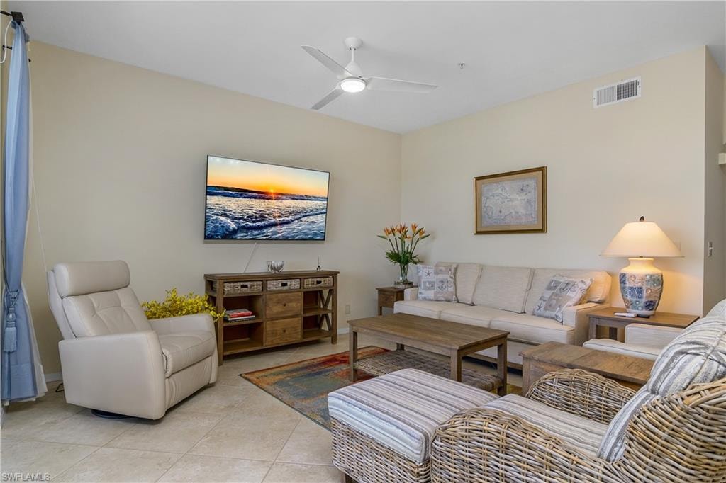 Living room featuring visible vents, ceiling fan, and light tile patterned floors