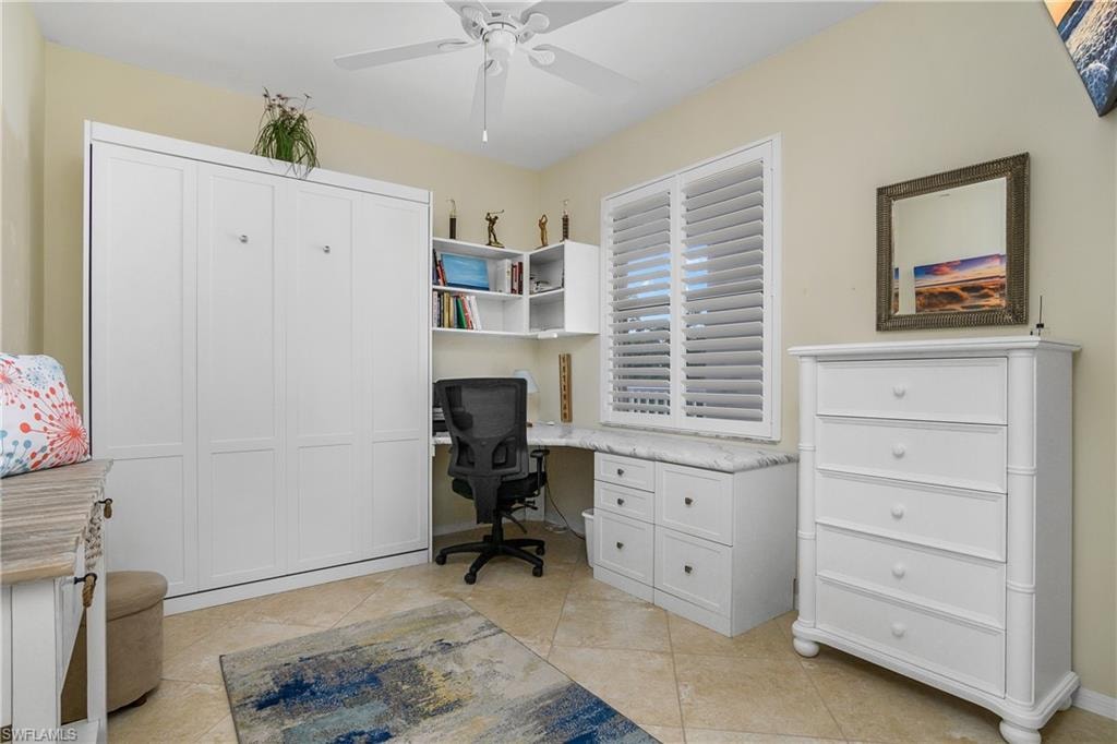 Office with a ceiling fan and light tile patterned floors