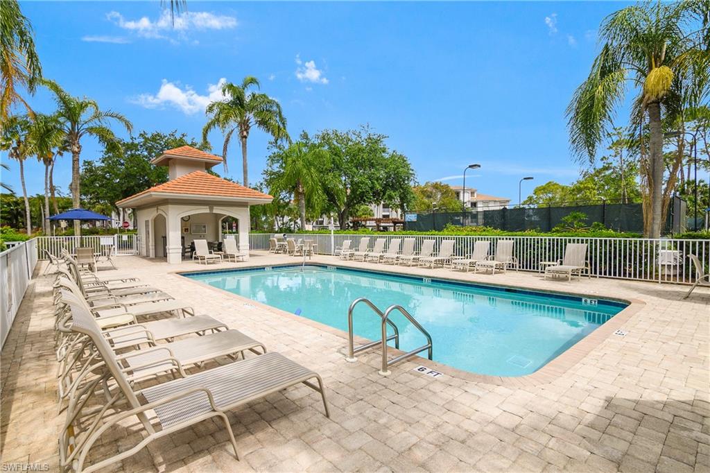 Community pool featuring a patio area and fence