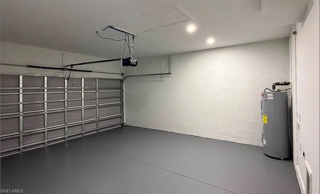 Garage with electric water heater and a textured wall