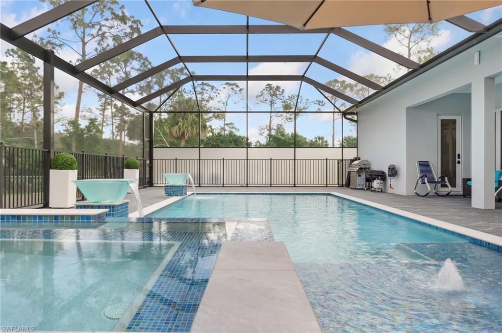 View of pool with a patio, a pool with connected hot tub, and a lanai