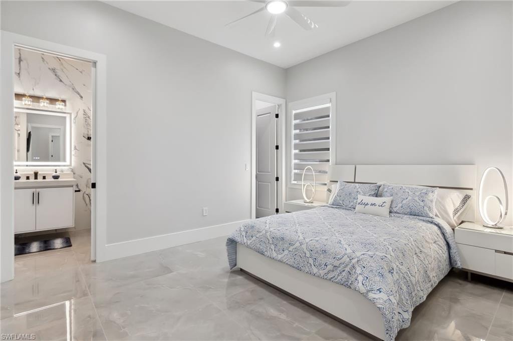 Bedroom featuring ceiling fan, ensuite bathroom, and baseboards