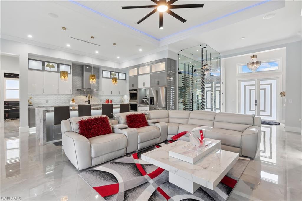 Living area featuring recessed lighting, marble finish floor, a ceiling fan, and ornamental molding