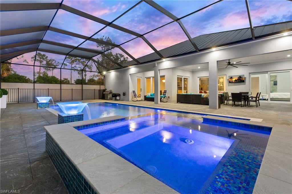Pool at dusk featuring a patio, a fenced in pool, an in ground hot tub, ceiling fan, and outdoor lounge area