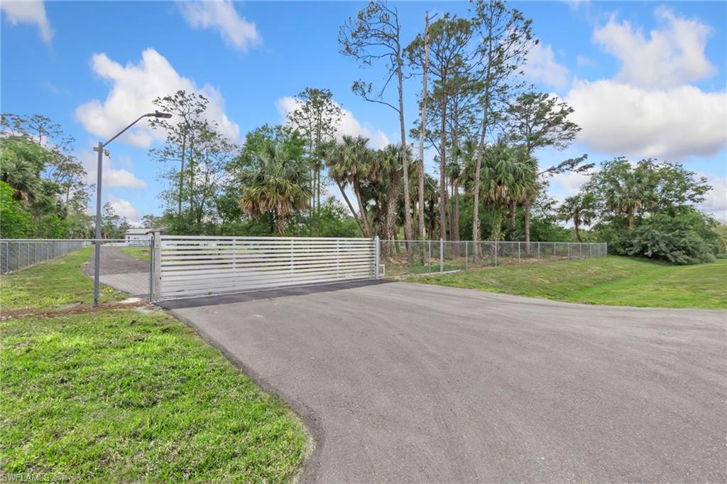 View of gate featuring a yard and fence