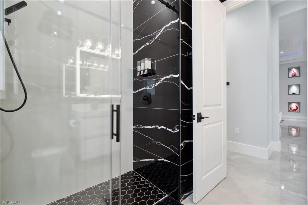 Bathroom featuring baseboards and a stall shower