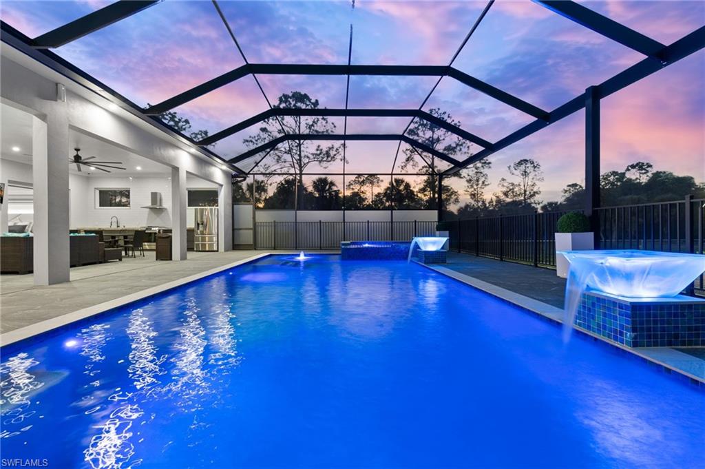 View of pool with an outdoor living space, a jacuzzi, a patio area, and fence