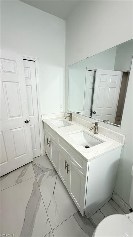 Full bath with double vanity and light marble finish flooring
