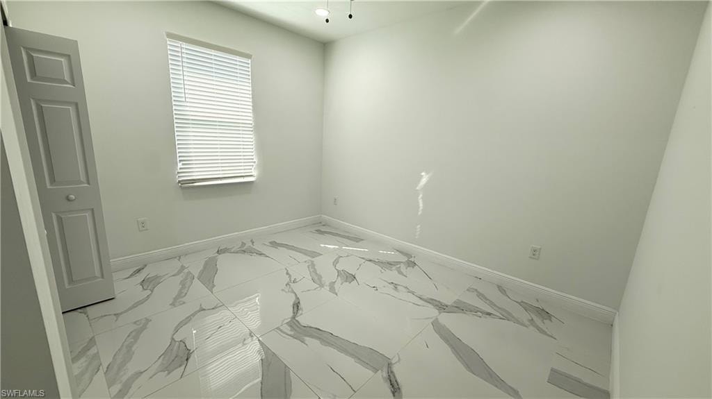 Empty room with baseboards and marble finish floors