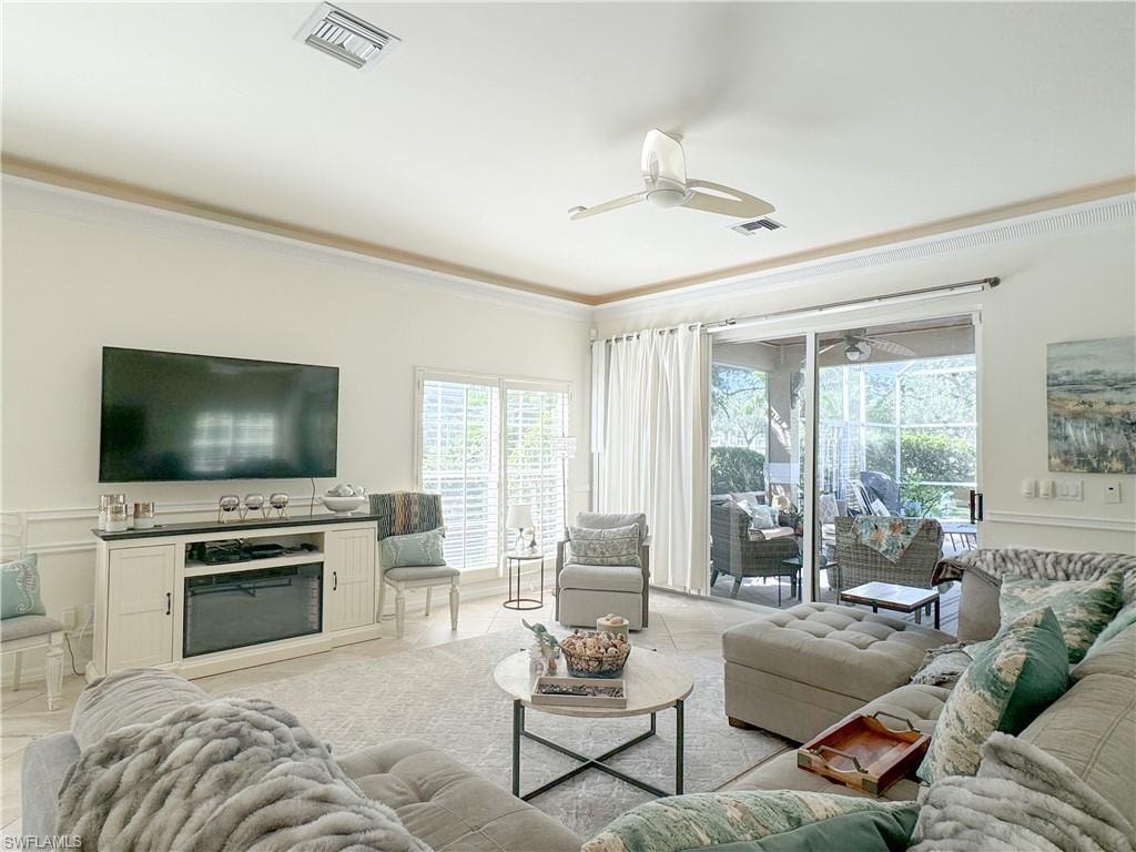 Tiled living room featuring crown molding and ceiling fan