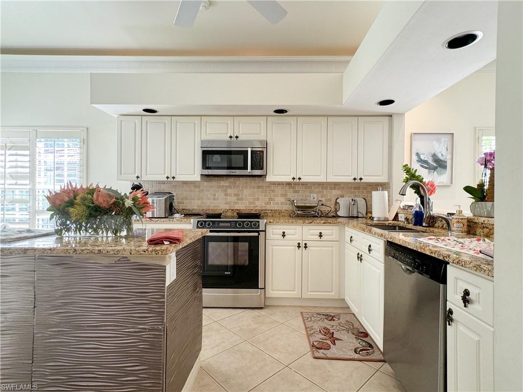 Kitchen with ceiling fan, light tile floors, sink, white cabinetry, and appliances with stainless steel finishes
