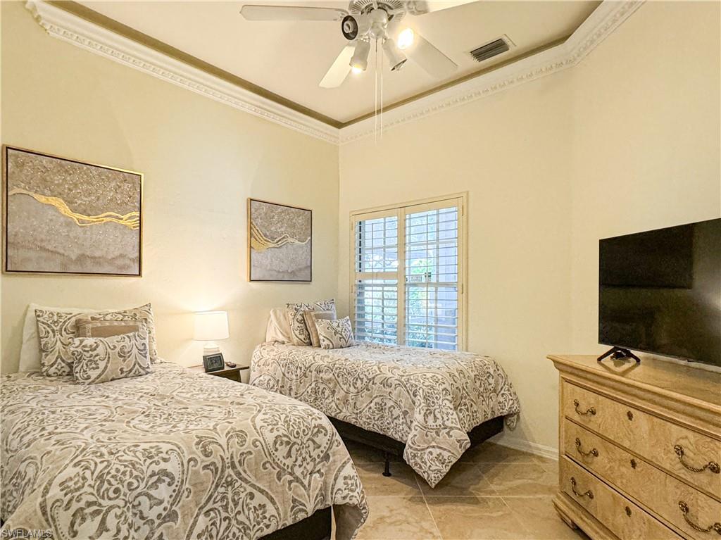 Bedroom featuring tile floors, ceiling fan, and ornamental molding