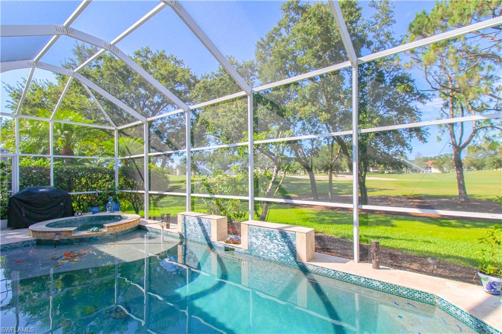 View of pool featuring a yard, a lanai, an in ground hot tub, and area for grilling