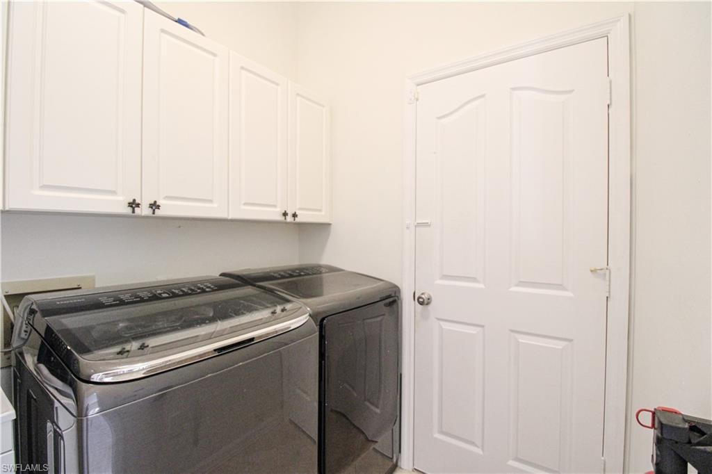 Laundry room with washer and dryer and cabinets
