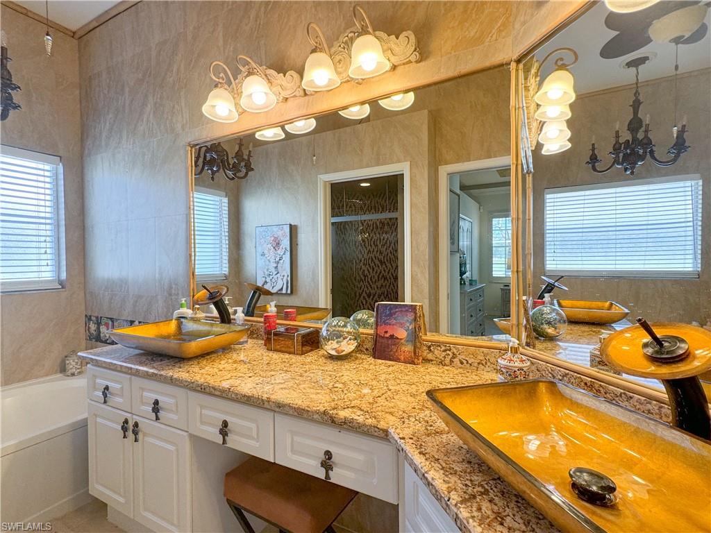 Bathroom featuring dual vanity and a washtub