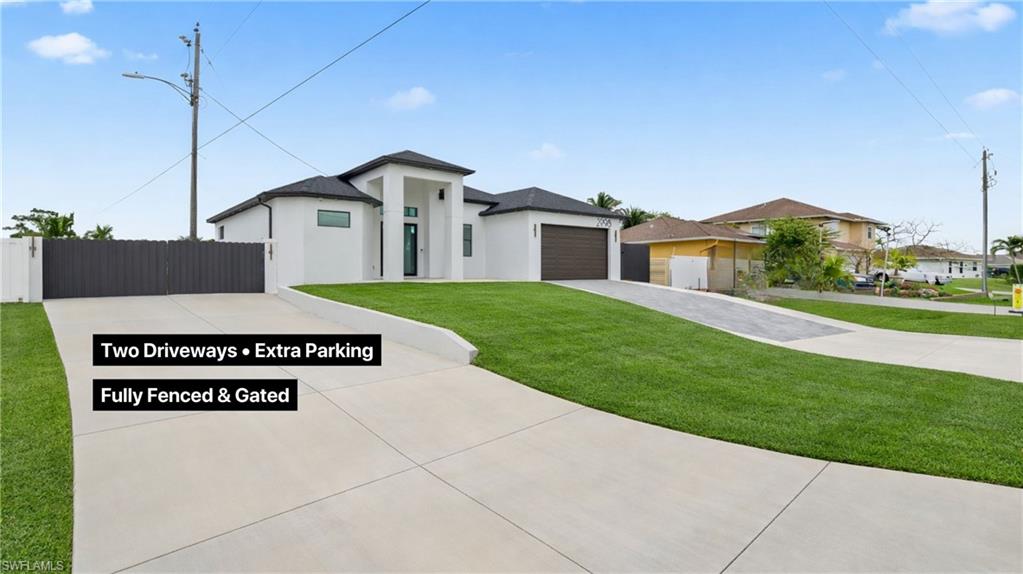 Prairie-style house featuring driveway, stucco siding, and a garage