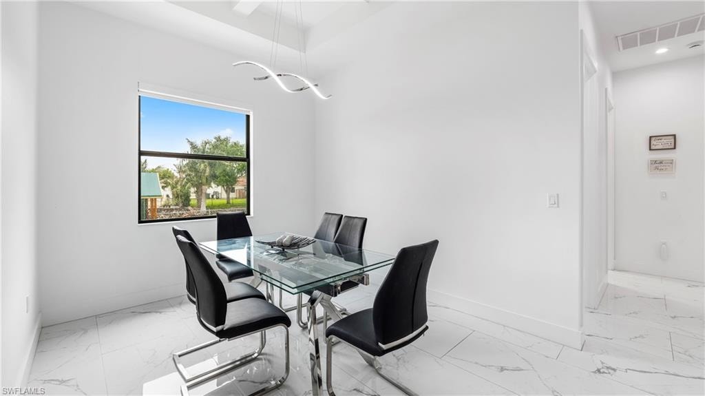 Dining room with light marble finish flooring and baseboards