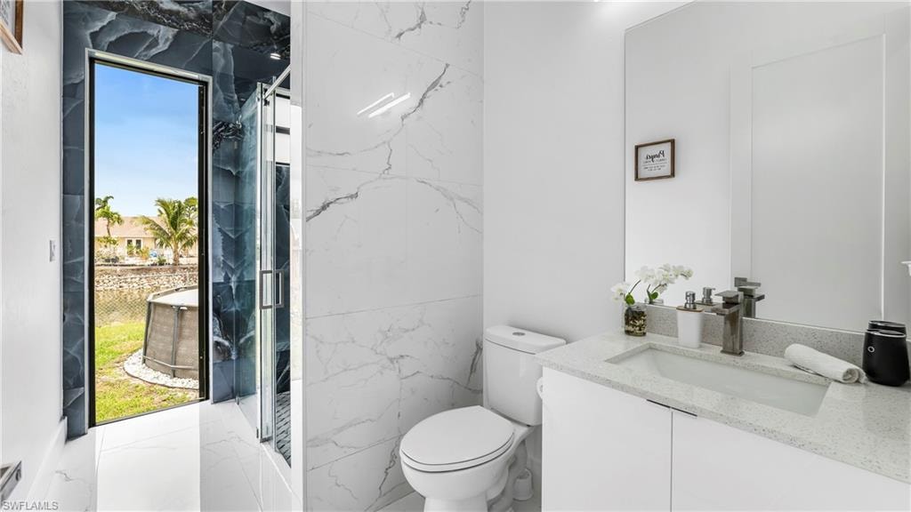 Bathroom with vanity and a marble finish shower