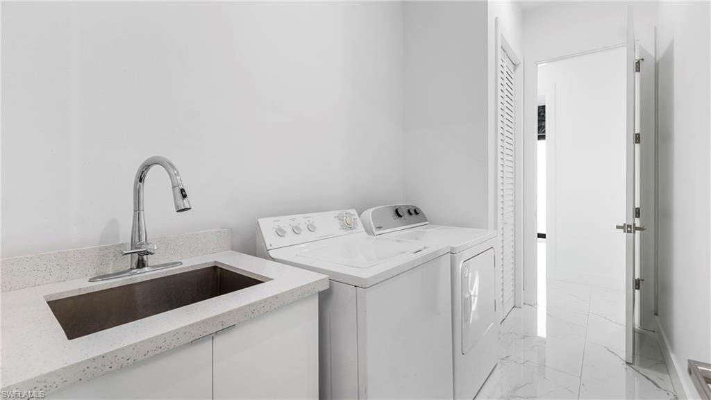 Laundry room with light marble finish flooring and washer and dryer