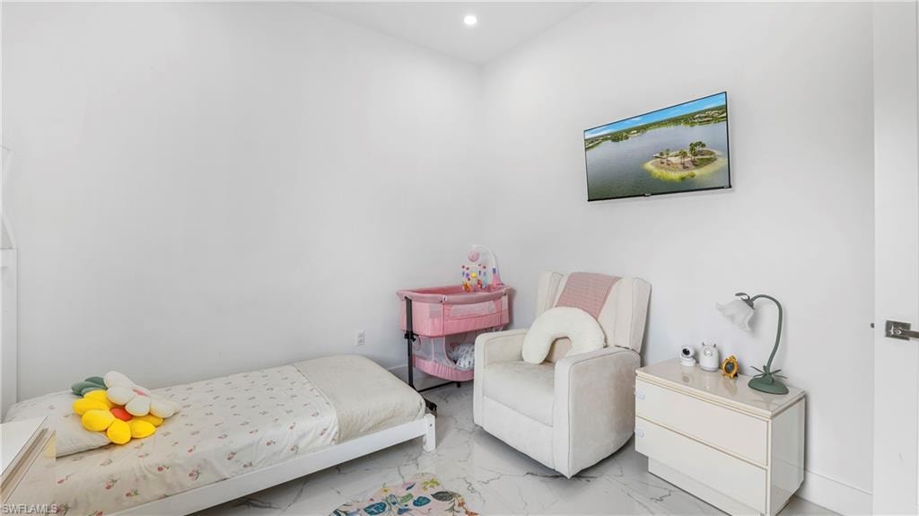 Bedroom featuring marble look tile flooring and recessed lighting