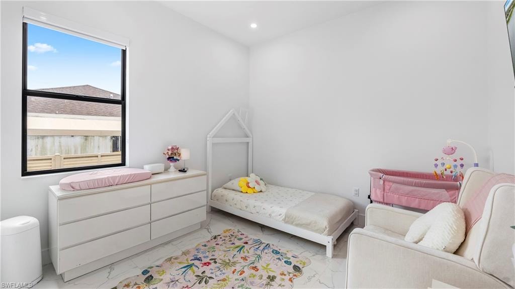 Bedroom with light marble finish floors and recessed lighting