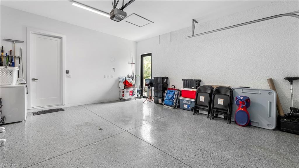 Garage featuring washer / clothes dryer and a garage door opener
