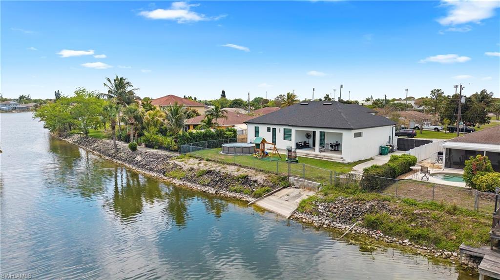 Back of house featuring a fenced backyard, a patio, and a water view
