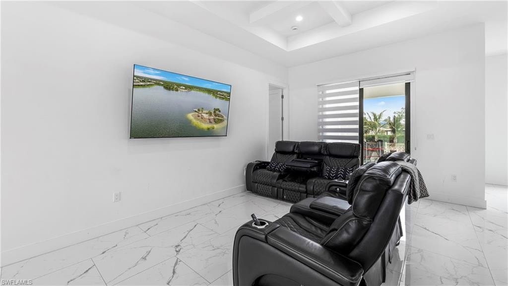 Living area featuring coffered ceiling, light marble finish floors, and recessed lighting