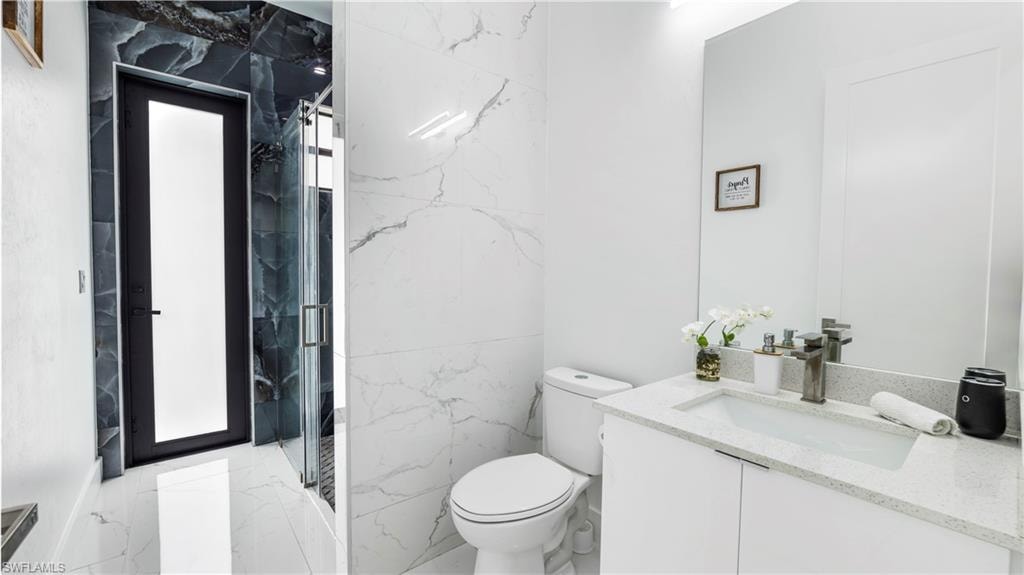 Bathroom with vanity and a marble finish shower