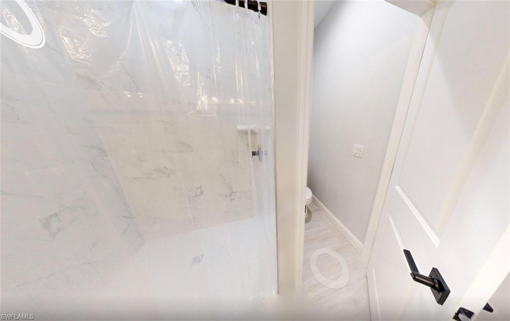 Bathroom with toilet and a marble finish shower