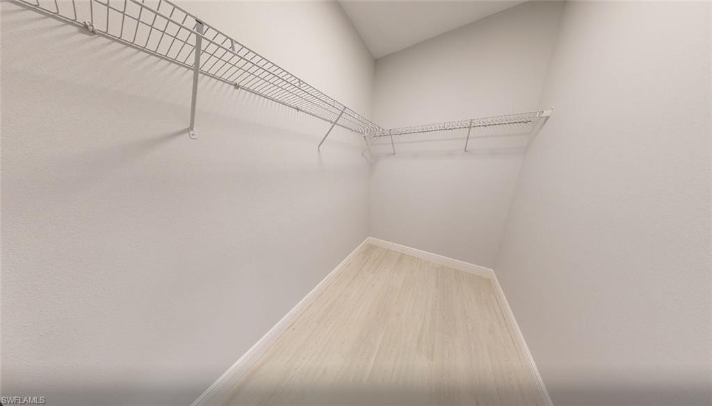 Walk in closet with wood finished floors