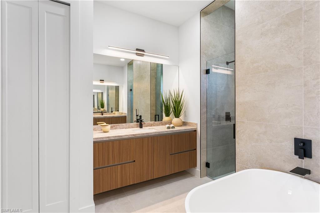 Primary spa bathroom with stand-alone tub, dual sinks, floating cabinetry and marble countertops!