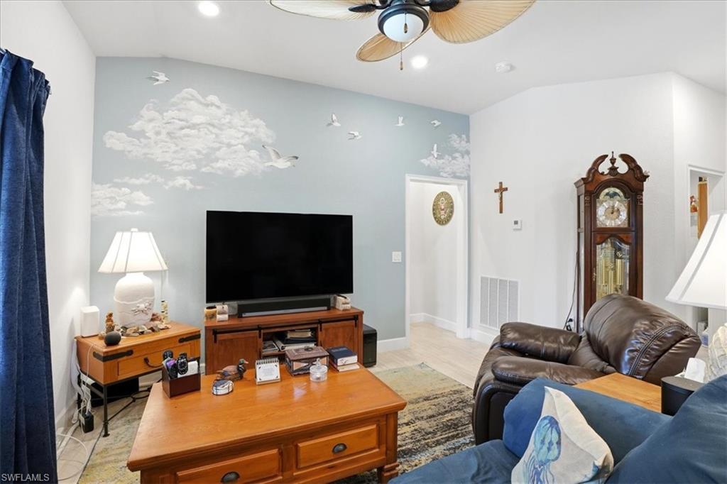 Carpeted bedroom with lofted ceiling and a ceiling fan