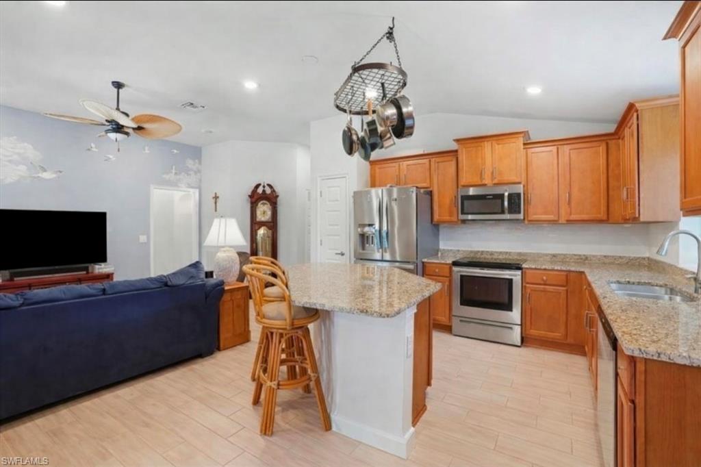 Bedroom with lofted ceiling, dark colored carpet, and a ceiling fan