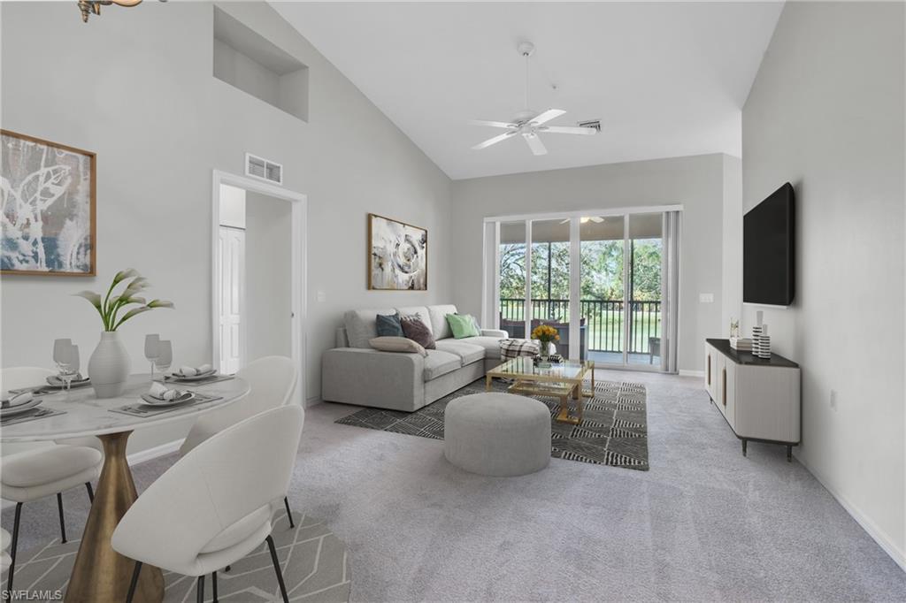 Living room featuring high vaulted ceiling, ceiling fan, and carpet flooring