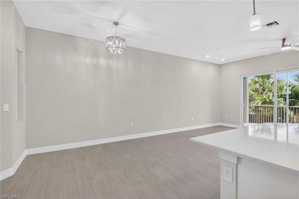 Unfurnished dining area with wood tiled floors, a ceiling fan, and hanging lights