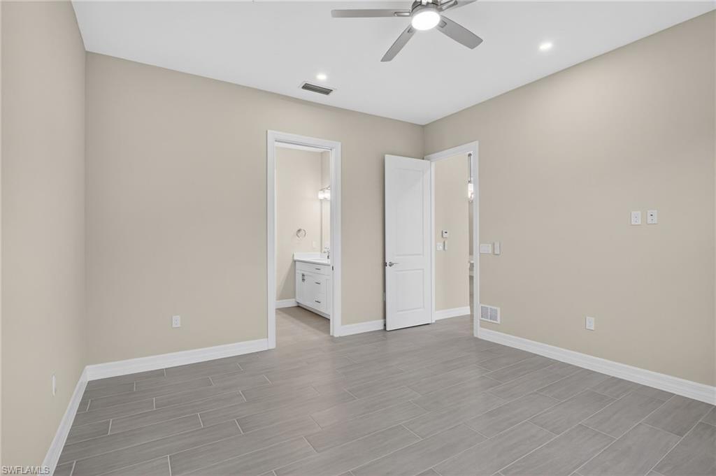 Unfurnished bedroom with ceiling fan, connected bathroom, wood tiled floors, and recessed lighting