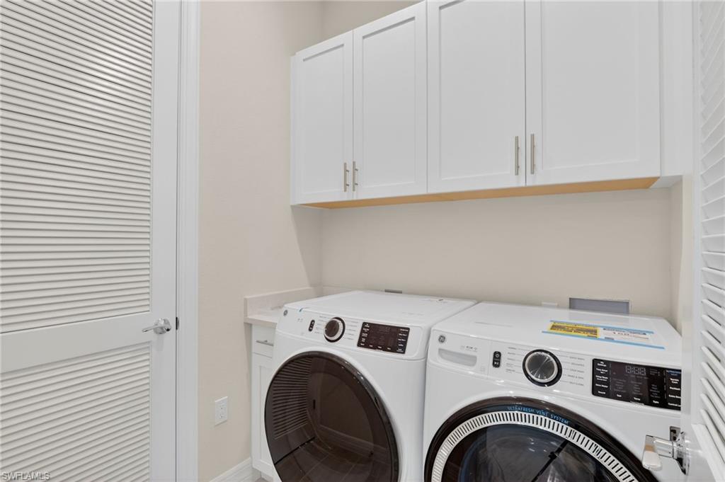 Laundry area with cabinet space and washer and clothes dryer