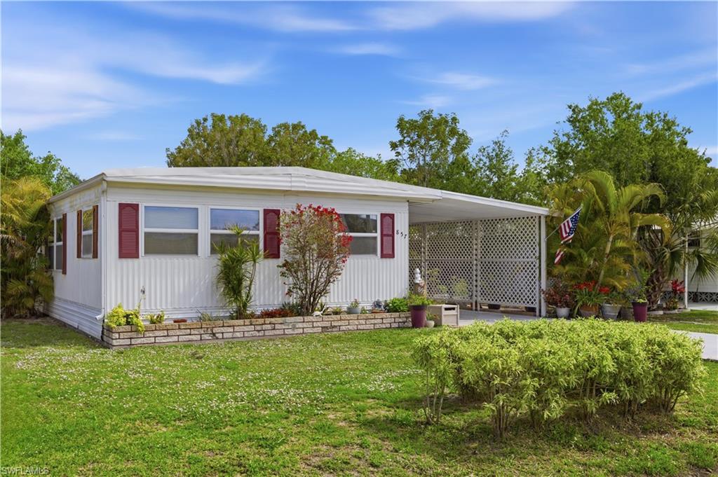 White siding residence with red decorative shutters