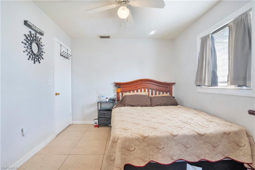 Bedroom featuring light tile patterned floors and a ceiling fan