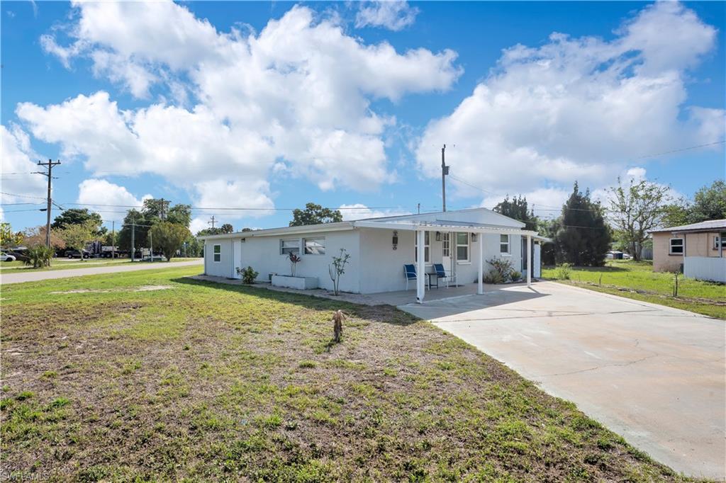 View of front of house featuring a front lawn, stucco siding, and driveway
