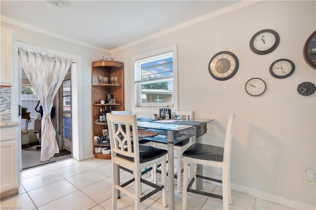 Dining space with light tile patterned floors and ornamental molding