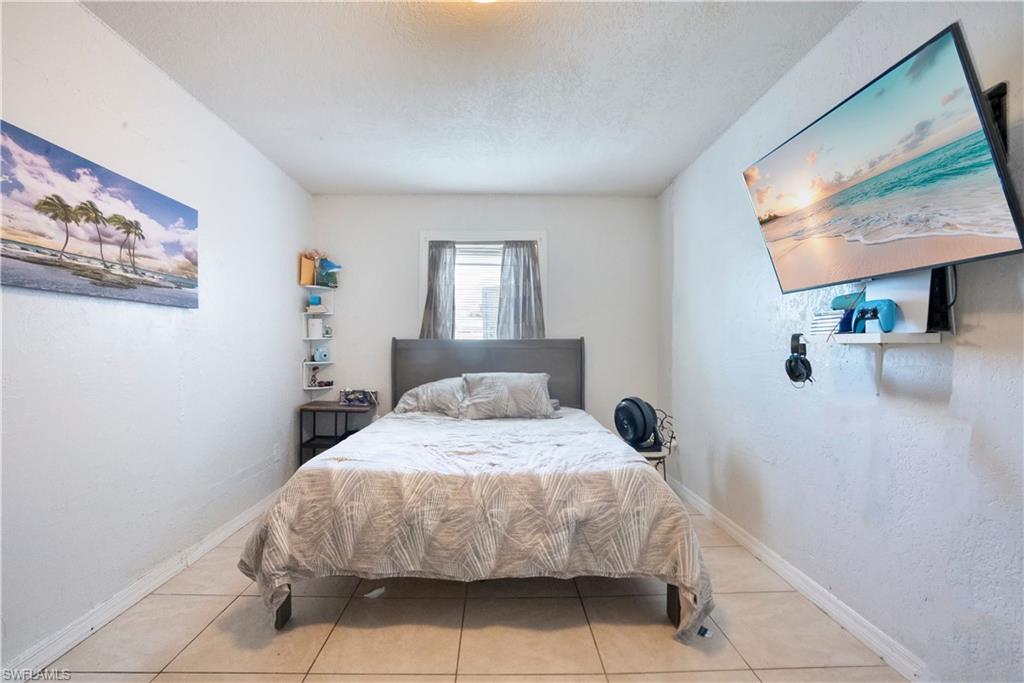 Bedroom with light tile patterned floors and a textured ceiling