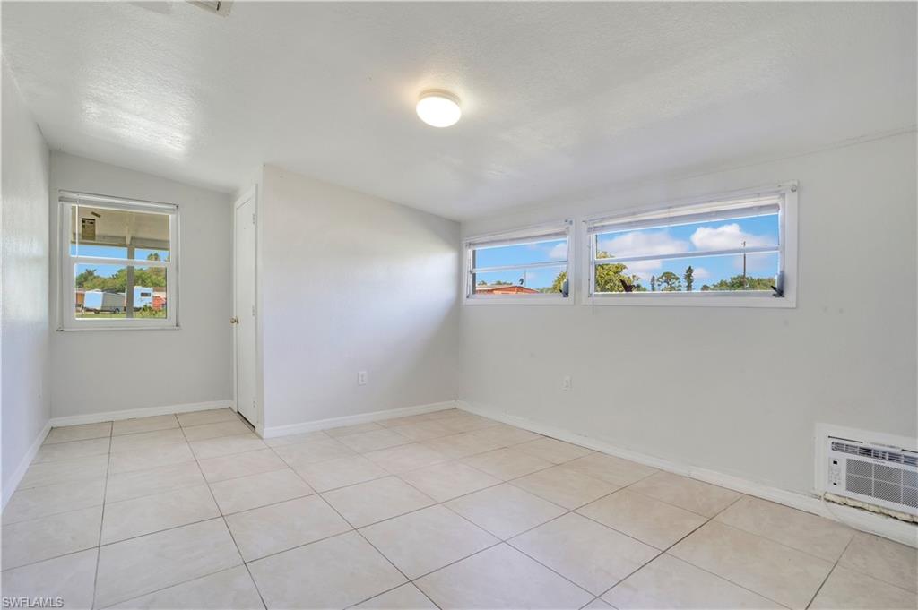 Empty room with lofted ceiling and light tile patterned floors