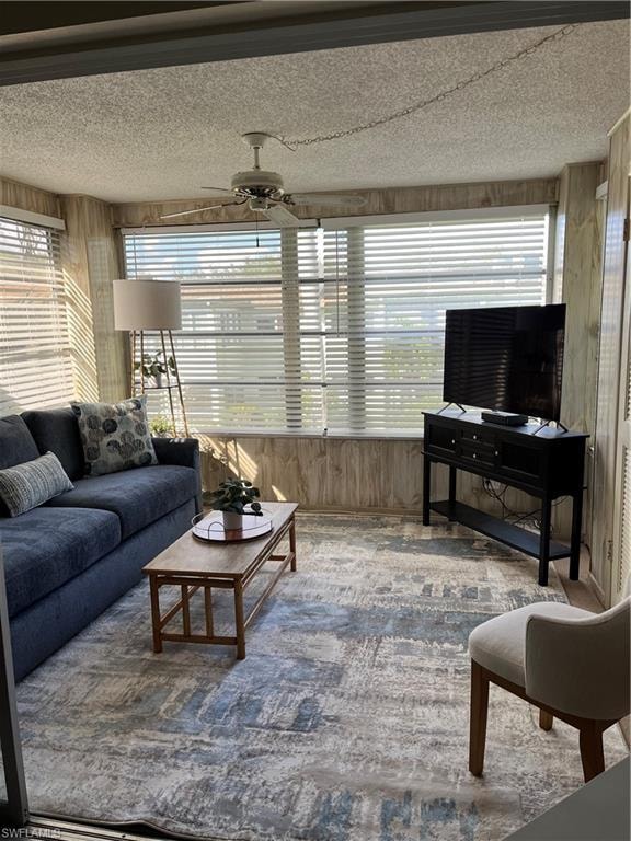 Carpeted living room has been turned into cozy Den with plenty of natural light and  ceiling fan,