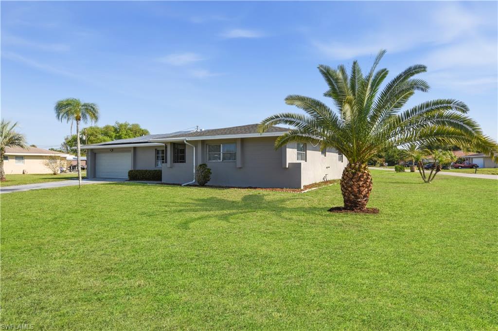 Single story home with an attached garage, a front yard, concrete driveway, and stucco siding