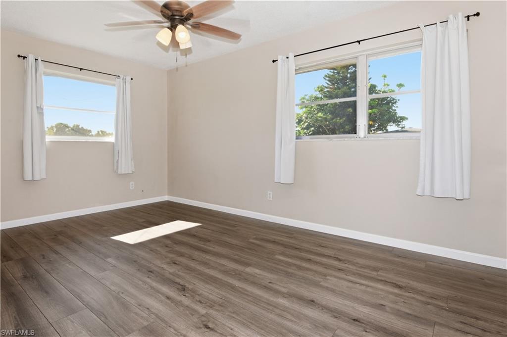 Spare room featuring dark wood-style flooring and ceiling fan
