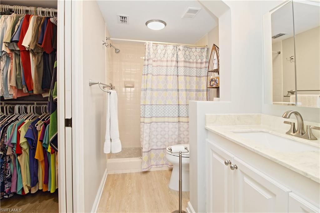 Primary bathroom with walk-in shower, raised vanity and walk-in closet